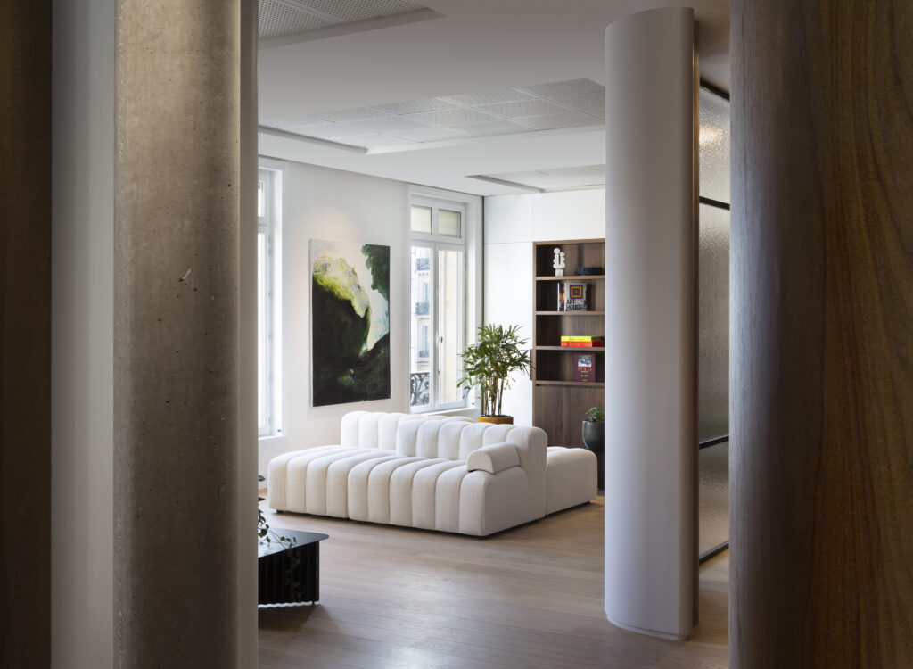 Espace lounge haut de gamme avec canapé blanc sur mesure, rénovation bureaux avenue de l’Opéra Paris, architecture intérieure luxe.