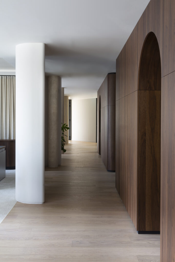 Couloir raffiné avec panneaux en bois et colonnes blanches, projet de bureaux de luxe avenue de l’Opéra Paris.